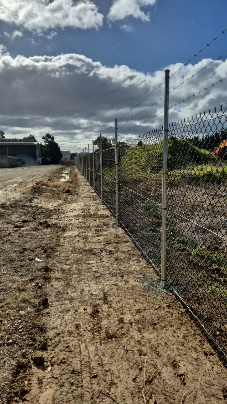 Completed black chain mesh security fence with barbed wire for Fowlers Asphalt in Bairnsdale